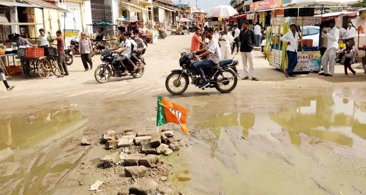 વાવ શહેરમાં રોડના અભાવે ખાડા અને કાદવ કીચડનું સામ્રાજ્ય વધતાં યુવકે ભાજપનો ધ્વજ મૂકી વિરોધ નોંધાવ્યો